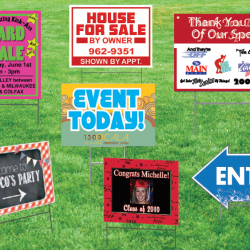 A variety of yard signs on a lawn.